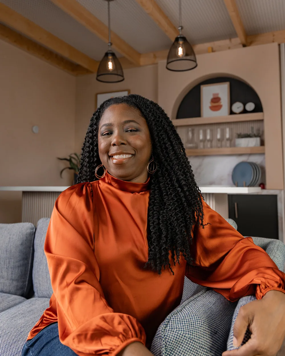 Keisha Ortiz, founder of Oasis Women Center, seated in a living room in warm natural light.